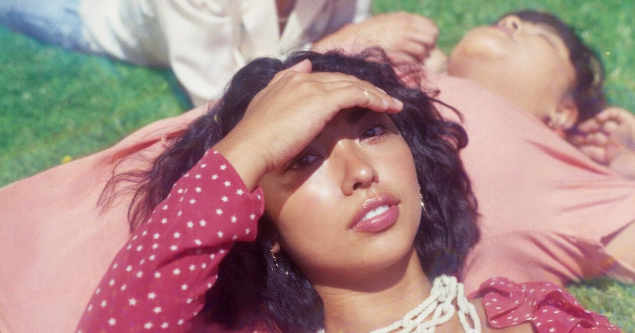Several teens lay in the grass and sun