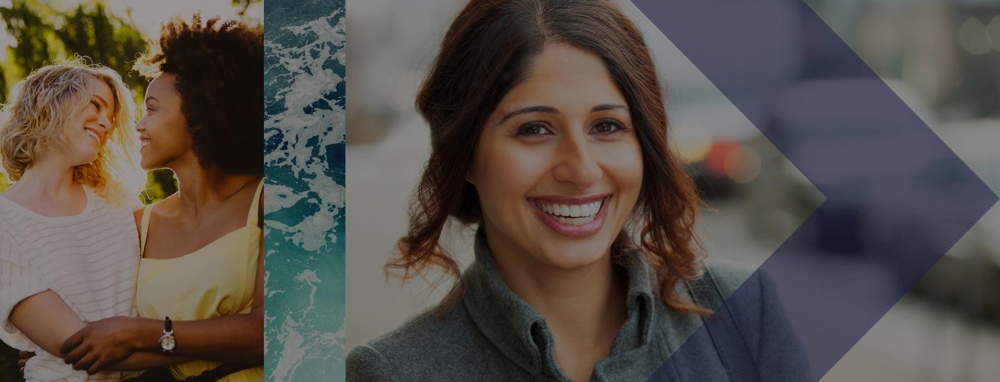 Two women hug and another woman smiles for the camera