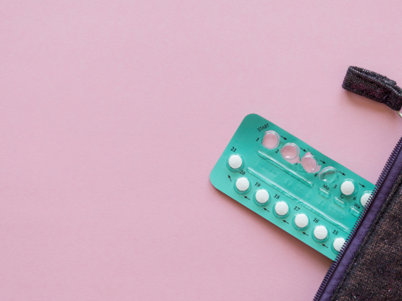 A pack of birth control pills spilling out of a purse