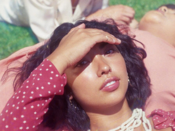 Several teens lay in the grass and sun