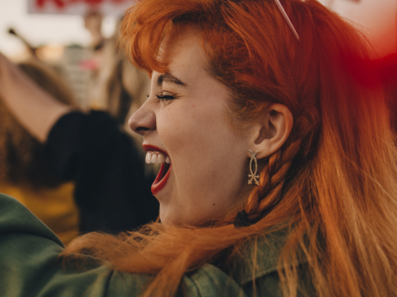 A woman at a protest raises a hand and yells. 