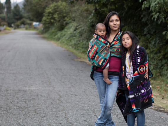A Native mother poses for a photo with her two children. 