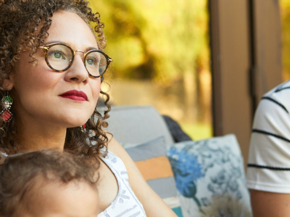 A mother sits outside with her child in her lap. 