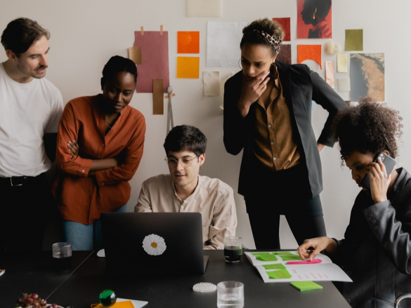 A photo of a team of men and women working together in an office. 